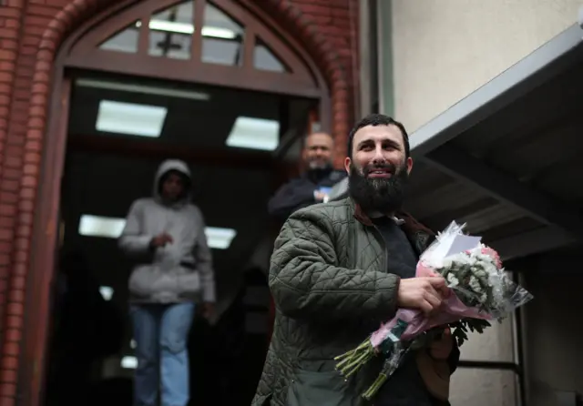 Man collecting flowers at Finsbury Park Mosque