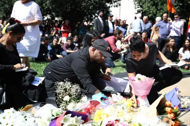 People place flowers and messages of condolence in Aotea Square in Auckland