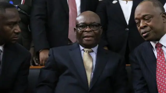 Suspended Chief Justice of Nigeria Walter Samuel Nkanu Onnoghen (C) talks to his lawyer