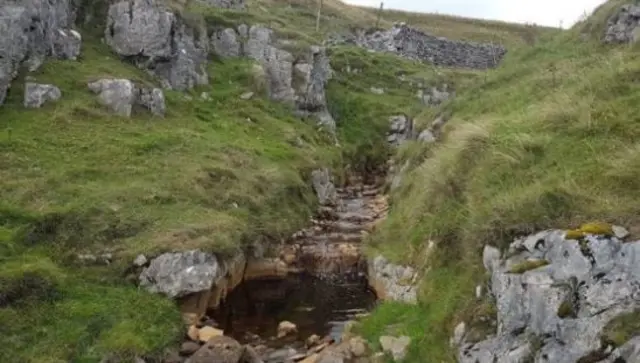 Mound where body was dislodged by heavy rain