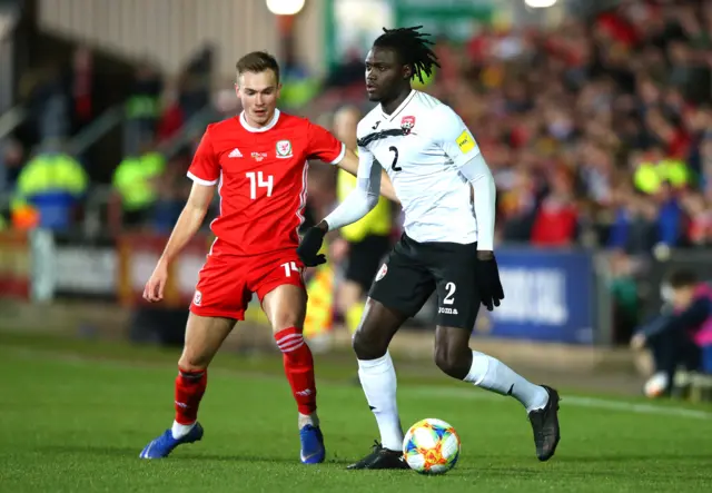 Aubrey David of Trinidad and Tobago battles for possession with Wales' Ryan Hedges