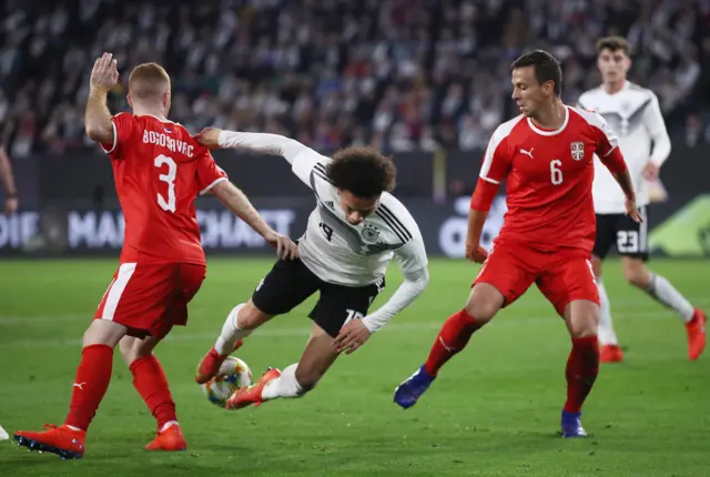 Leroy Sane of Germany is tackled by Serbia's Miroslav Bogosavac