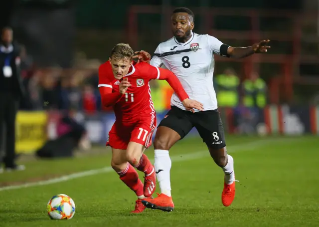 George Thomas of Wales battles for possession with Khaleem Hyland of Trinidad and Tobago