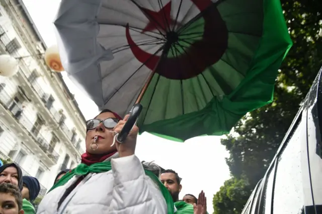 Anti-Bouteflika protester carrying an umbrella