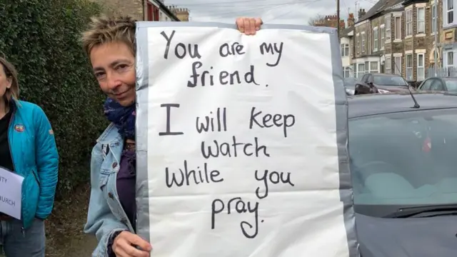 A sign saying "You are my friend. I will keep watch while you pray."