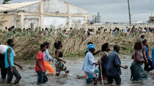 People wading through flood waters