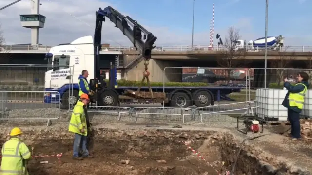 The cannon being picked up using a crane