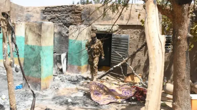 Soldier walking in burned compound