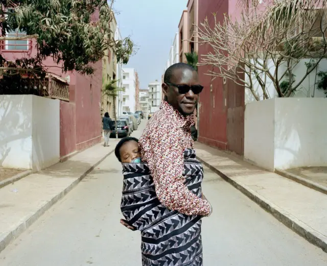 Man carrying a baby on his back