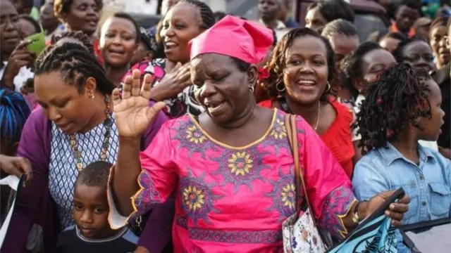 Woman praying at arrival of pope