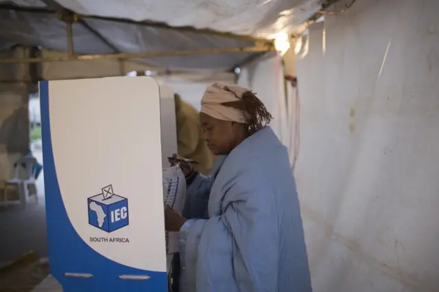 A South African woman looks at her ballot before casting her vote in the country's fourth democratic general elections on April 22, 2009 at a voting station in Khayelitsha township on the outskirt of Cape Town, South Africa.