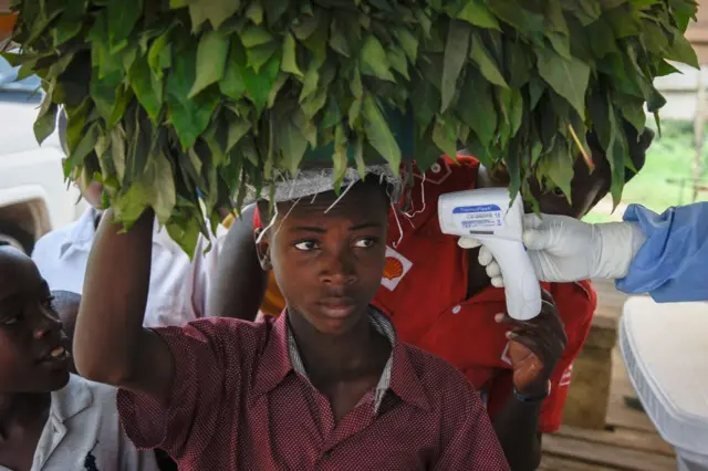 A young man from Democratic Republic of Congo (DRC) has his temperature checked by a non-contact thermometer at the Ebola screening point bordering with DRC in Mpondwe, western Uganda, on December 12, 2018