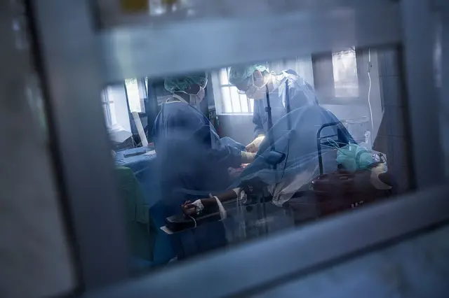 Doctors give emergency treatment to a new born baby whose mother undergoes Caesarean section after she is hospitalised with an infection in Gondama Referral Centre on March 9, 2014 in Bo District, Sierra Leone