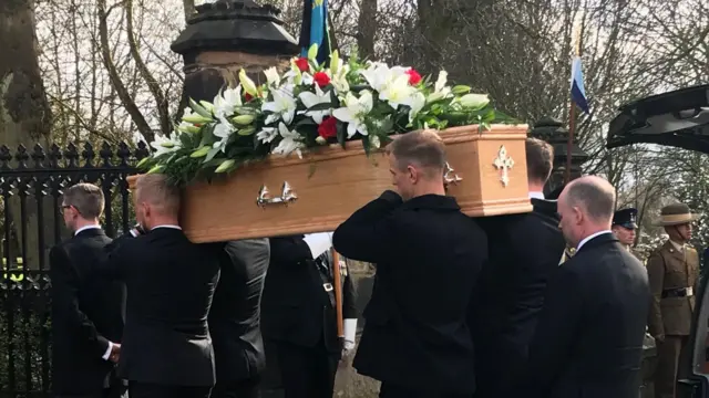 Coffin being carried in