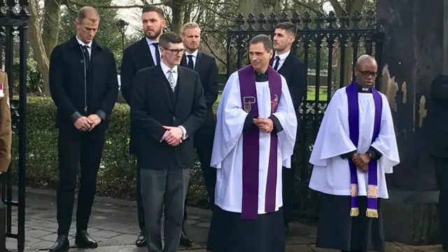 Pall bearers and clergy waiting for cortege