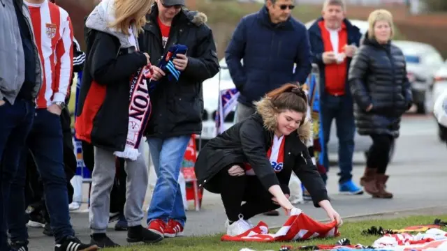 Fans laying a tribute at the stadium