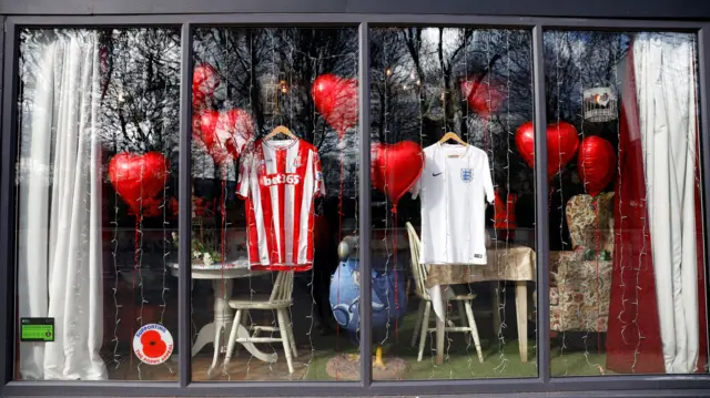 Tributes are seen in a shop window