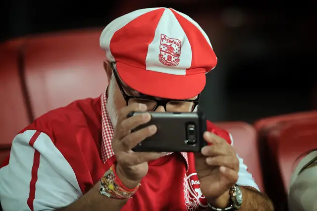 Arsenal fan checks his phone