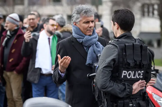 Algerian businessman and political activist Rachid Nekkaz (L) argues with a police officer