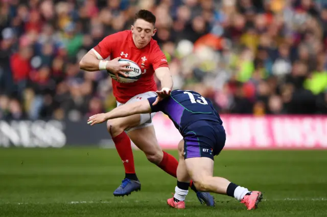 Josh Adams of Wales is tackled by Scotland's Nick Grigg