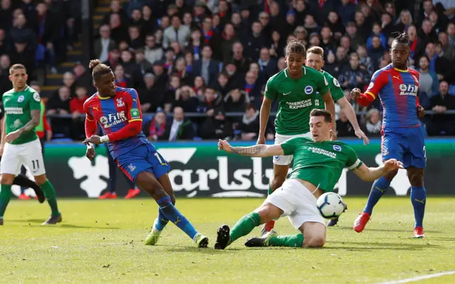 Lewis Dunk blocks Wilfried Zaha's shot