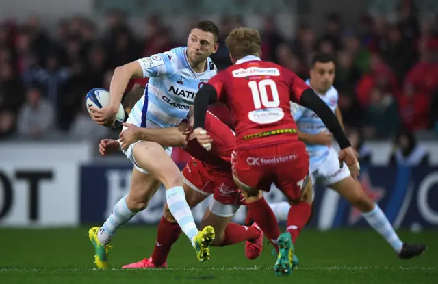 Finn Russell of Racing 92 off-loads out of the tackle of Scarlets' Hadleigh Parkes