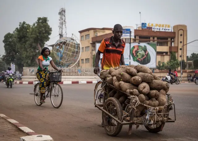 Man pushing a cart full of yams in Burkina Faso's capital, Ouagadougou