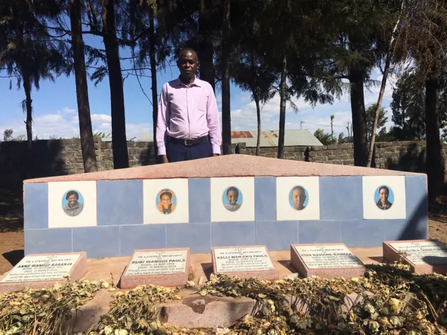 Kenyan John Quindos Karanja stands next to a memorial stone with pictures of his family members who lost their lives in the Ethiopian Airlines ET302 crash.