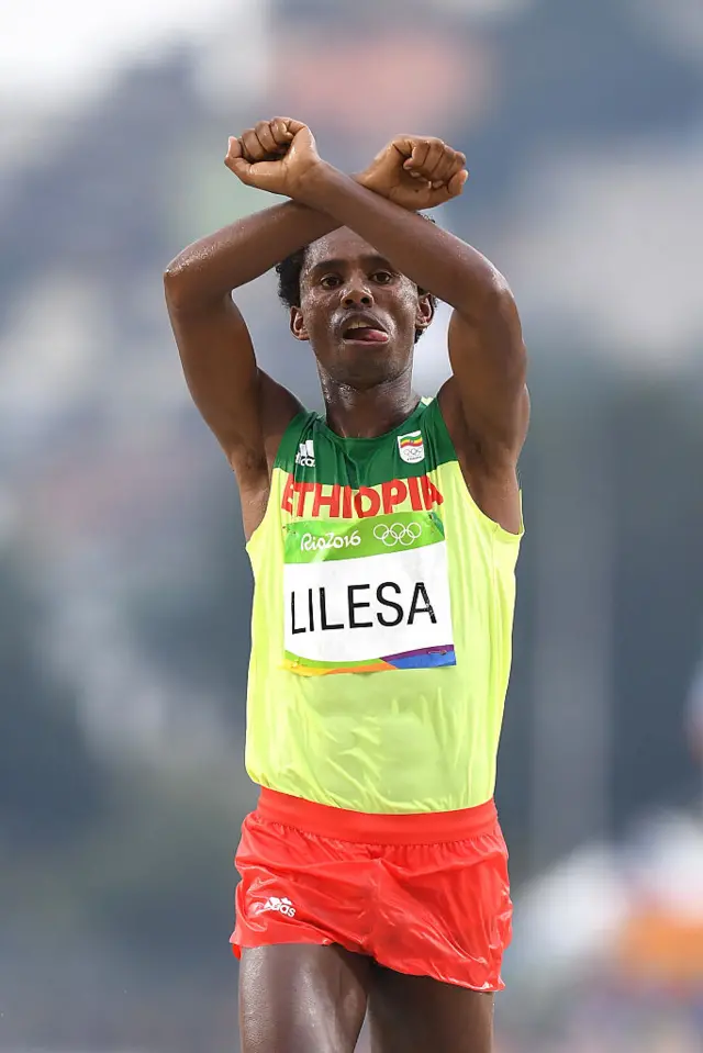 Feyisa Lilesa of Ethiopia celebrates as he crosses the line to win silver during the Men's Marathon on Day 16 of the Rio 2016 Olympic Games at Sambodromo on August 21, 2016 in Rio de Janeiro, Brazil.