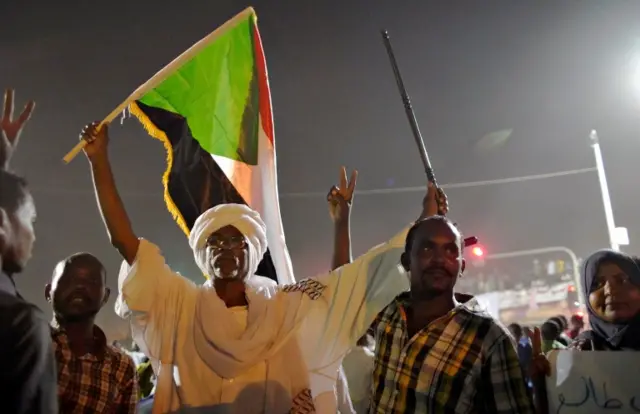 Demonstrators wave their national flag as they attend a protest rally demanding Sudanese President Omar Al-Bashir to step down outside Defence Ministry in Khartoum, Sudan April 10, 2019.