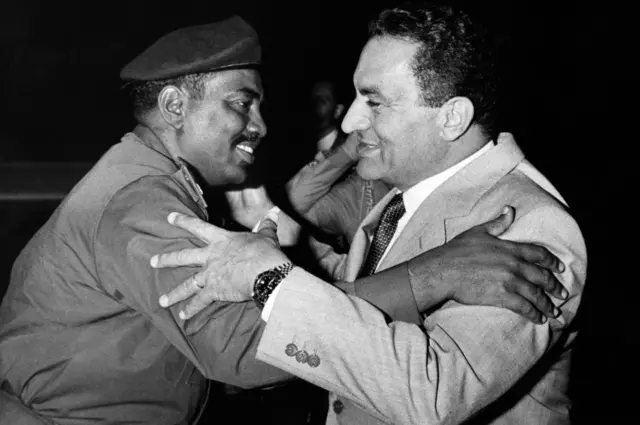 July 12, 1989, Egyptian president Hosni Mubarak (R) greets new Sudanese Prime minister General Omar al-Bashir upon at his arrival in Cairo