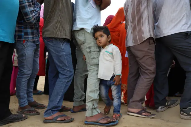 A little boy amid a long queue of voters outside a polling booth in Ghaziabad in Uttar Pradesh state.