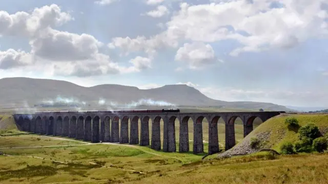 A vintage steam train passes over the Ribblehead viaduct in North Yorkshire