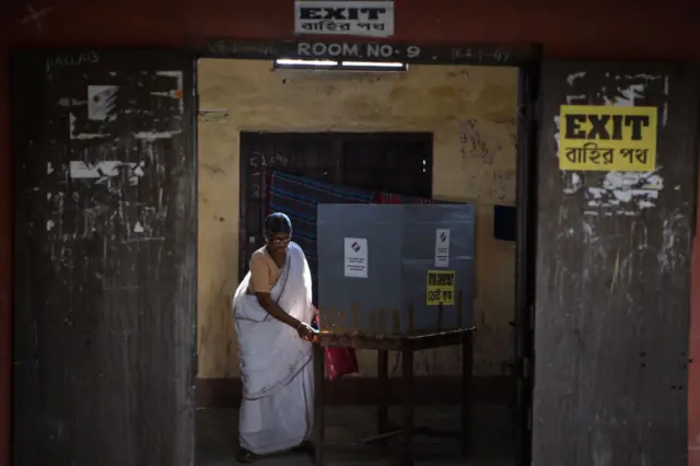 A woman votes in a booth at a polling station during India's general election in Cooch Behar, West Bengal on April 11, 2019