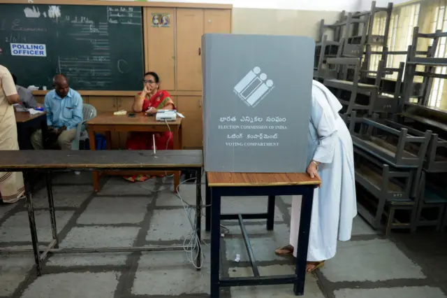 An Indian Catholic nun votes in a booth at a polling station during India's general election in Hyderabad on April 11, 2019