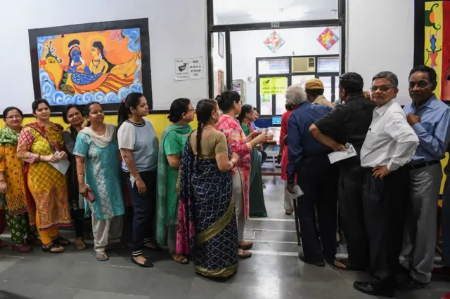 People line up to vote at a polling station during India's general election in Ghaziabad, Uttar Pradesh on April 11, 2019