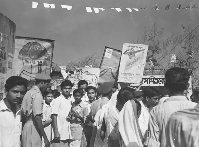 Placards and banners being carried by boys canvassing for political parties during the Indian general election