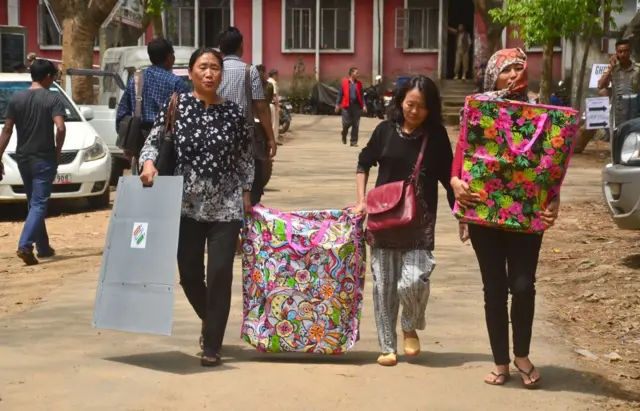 Women Election Official carries Electronic Voting Machine (EVM) to be transported to respective polling station for the first phase of India Lok Shaba Election in Dimapur, India North eastern state of Nagaland