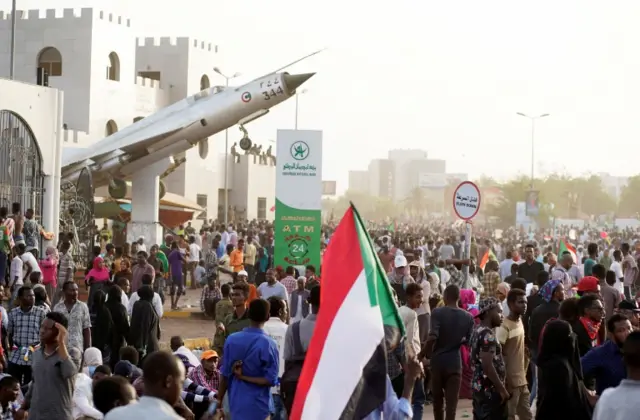 Sudanese demonstrators hold national flags and chant slogans as they protest against the army's announcement that President Omar al-Bashir would be replaced by a military-led transitional council, outside Defence Ministry in Khartoum, Sudan April 11.