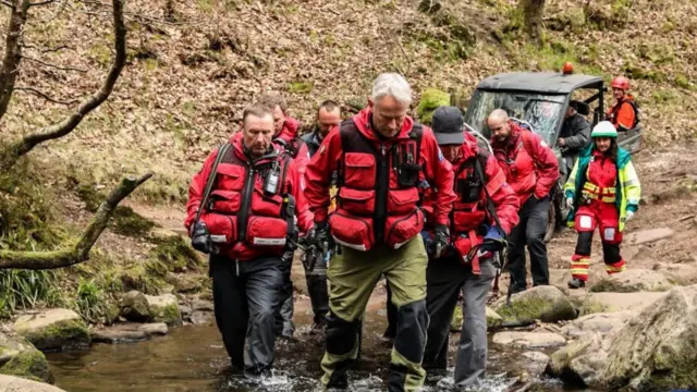 Mountain rescue team carrying victim on stretcher