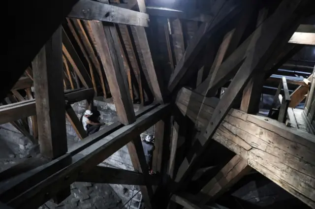 In this photo from June 2018, workers are seen repairing the wooden roof