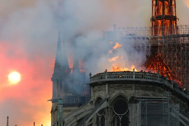 Smoke billows as flames destroy the roof of the landmark Notre-Dame Cathedral in central Paris