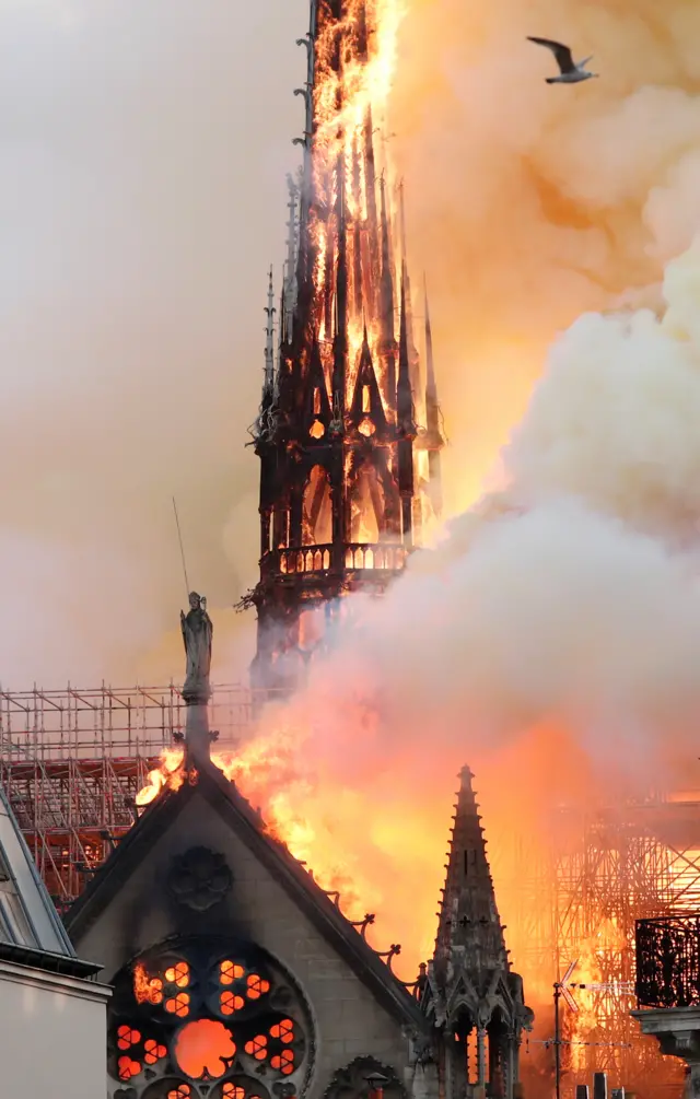 Smoke billows as fire engulfs the spire of Notre Dame Cathedral in Paris