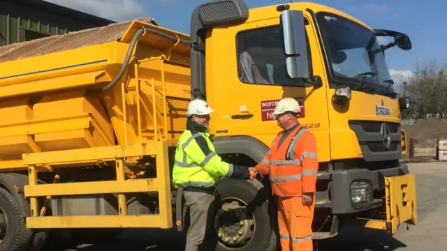 Men shaking hands by a gritter