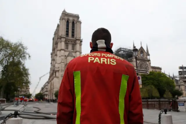 A firefighter stands outside Notre-Dame