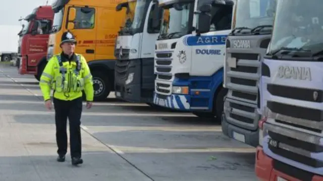 A police officer looking at some lorries