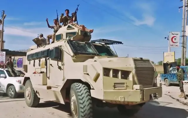 This grab obtained from a video published on the Libyan strongman Khalifa Haftar's self-proclaimed Libyan National Army War Information Division's Facebook page on April 16, 2019, shows fighters riding atop an armoured vehicle waving gestures and chanting slogans while driving reportedly in a southern suburb of the capital Tripoli