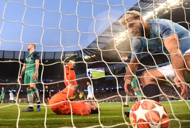 A wild-eyed Sergio Aguero takes the ball out of the Tottenham net as Spurs goalkeeper Hugo Lloris lies prone on his back