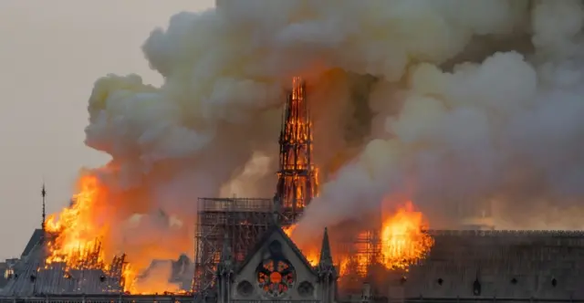 Smoke billows as flames burn through the roof of the Notre-Dame de Paris Cathedral on April 15, 2019