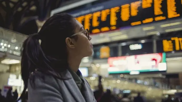 Person looking at departure boards at station